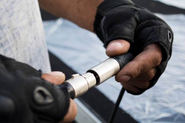 istock XLR, connector with wires in worn hands on stage 994920662