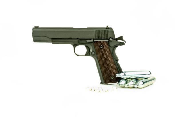 istock Profile view of isolated semi-automatic airsoft handgun with bullets and gas container. Replica of real handgun on white background. 994945628