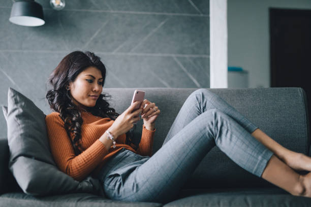 istock Woman relaxing at home, texting with her friends 994948064