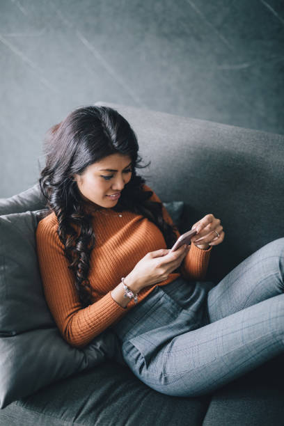 istock Woman relaxing at home, texting with her friends 994948066