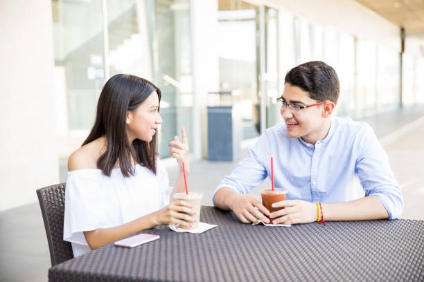 istock Teenage Couple Talking While Having Drinks In Shopping Mall 994958818