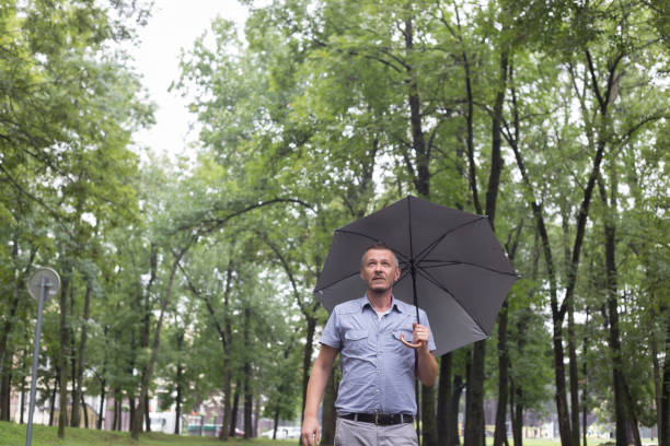 istock Adult man walking outdoors on rainy summer day 995002946