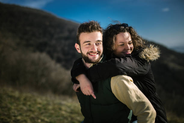 istock Young man carrying a friend on his back on hiking. 995022152