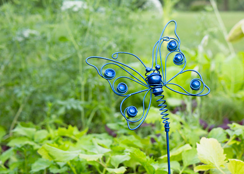 Blue decorative metal butterfly in grass