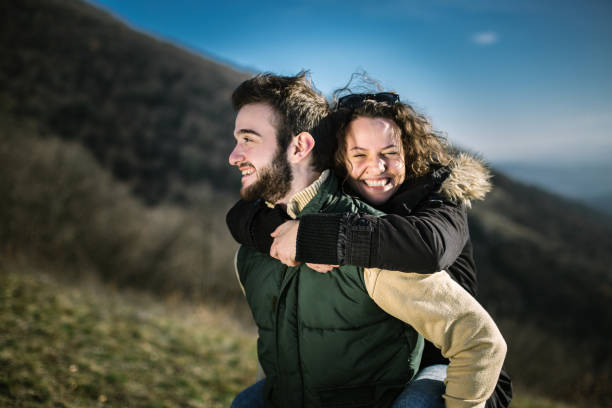 istock Young man carrying a friend on his back on hiking. 995022760