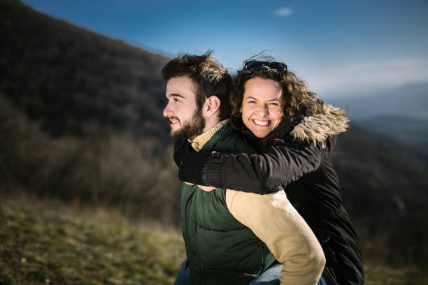 istock Young man carrying a friend on his back on hiking. 995024656