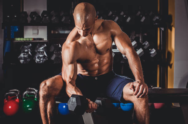 istock Man exercising with dumbbells in gym 995038420