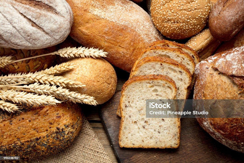 heap of bread heap of various bread on wooden background Bread Stock Photo