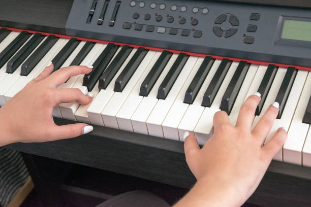 istock Woman's hands playing on electric piano 995088194