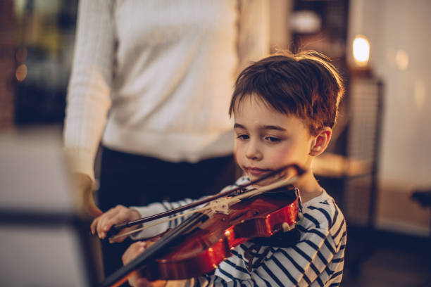 Adorable little boy teaching to play violin