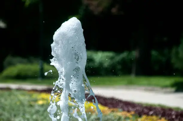 A close snapshot of gushing water with bizarre forms from a fountain in a park