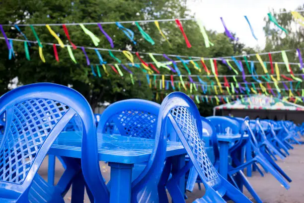 Photo of empty blue plastic chairs and tables outside, preparing for the holiday, no people