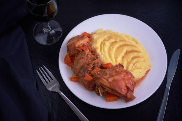 istock Chicken meat under souce with carrots and onions and smashed potatoes on black table 995100104