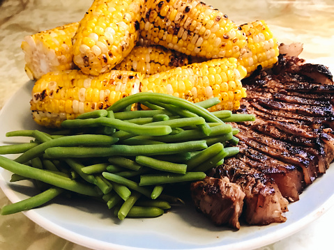 Home cooked dinner of barbecued steak and corn with green beans. Shot with an iPhone7.