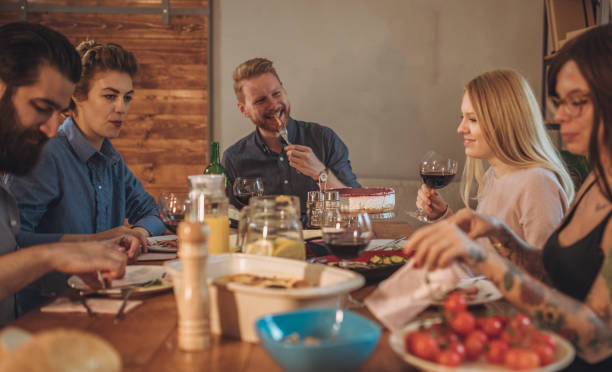 istock Group of happy friends eating at dining table 995102582