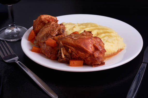 istock Chicken meat under souce with carrots and onions and smashed potatoes on black table 995102626