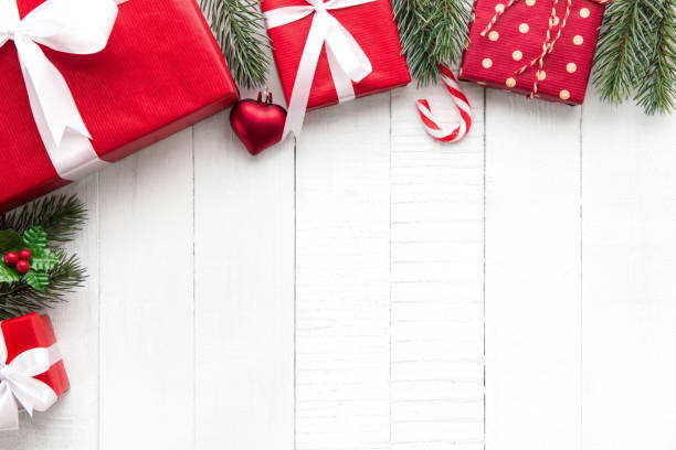 istock Christmas gift boxes with decorating ornaments on white wood background border design 995116832
