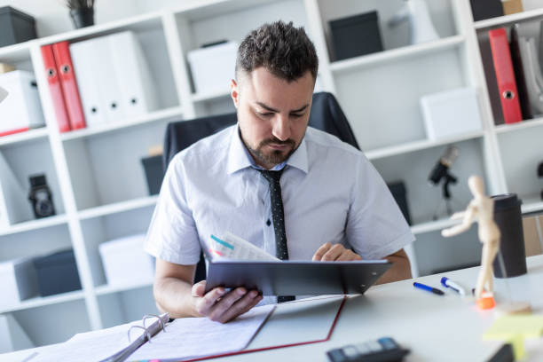 istock A man is sitting in the office and scrolls through the documents. 995117136