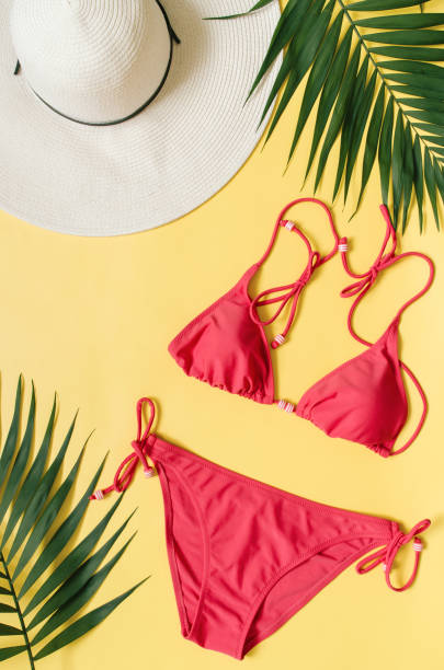 istock Beach apparel and tropical palm leaves arranged on yellow background 995117524