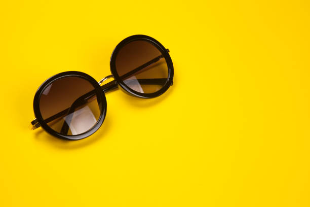 istock Stylish sunglasses on yellow background 995127878