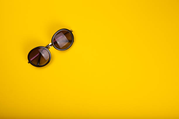 istock Stylish sunglasses on yellow background 995127892
