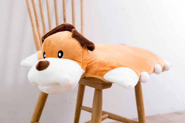 istock Yellow plush puppy pillows on a chair 995133422
