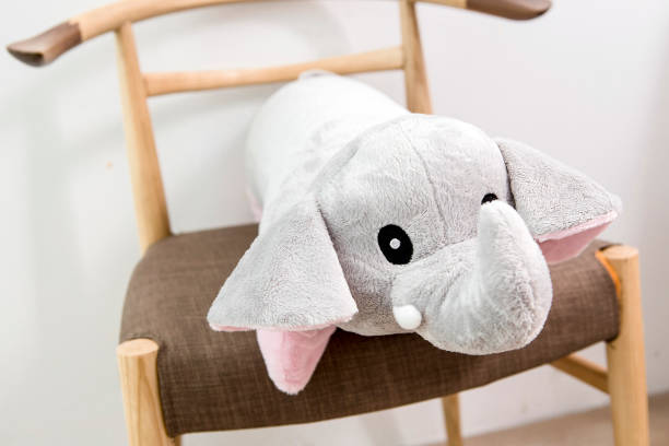 istock Gray plush elephant pillow on a chair 995133442