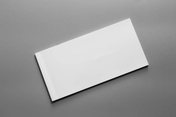istock Blank portrait A4. brochure magazine isolated on gray, changeable background / white paper business card isolated on gray 995149278