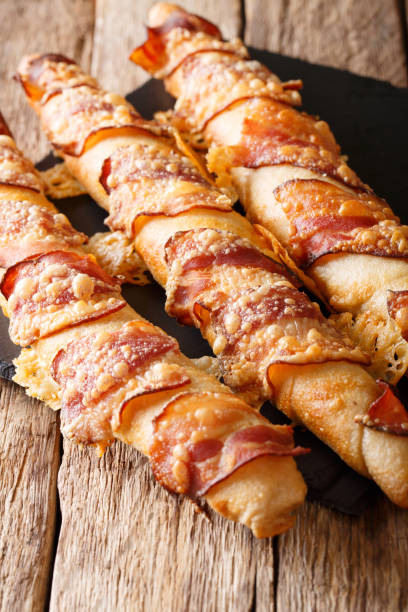 du pain délicieux bâtons avec bacon et fromage gros plan. vertical - twisted cheese biscuit pastry photos et images de collection