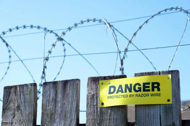 Razor wire fence protection danger sign on fence
 uk