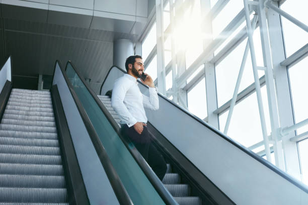istock Business Man Talking On Mobile Phone In Office On Stairs 995282316