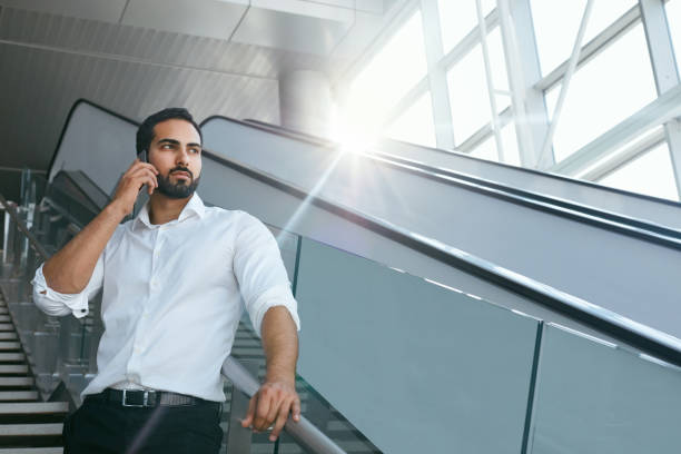 istock Business Man Talking On Mobile Phone In Office On Stairs 995284918