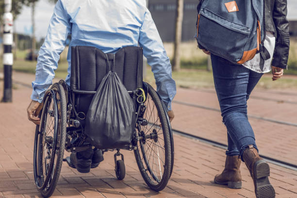 istock Wheelchair using young man and his girlfriend travelling around a modern city 995288002