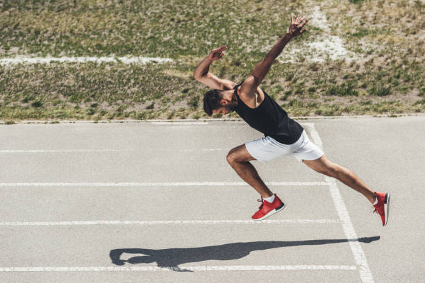 istock high angle view of male sprinter taking off from low start on running track 995291522