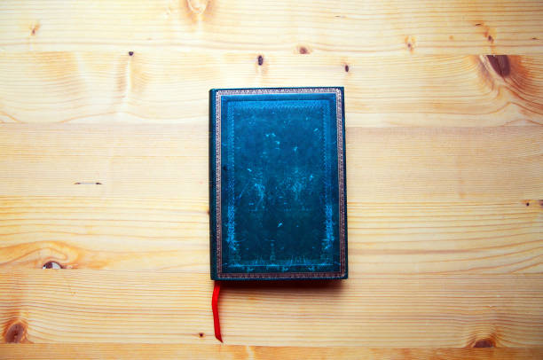 istock Dark green journal on wooden table 995294570