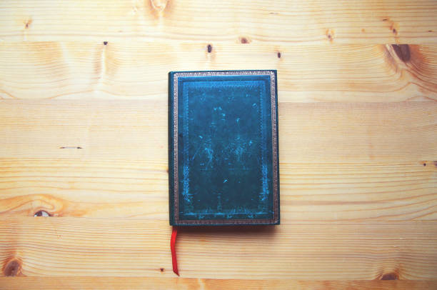 istock Dark green journal on wooden table 995294766