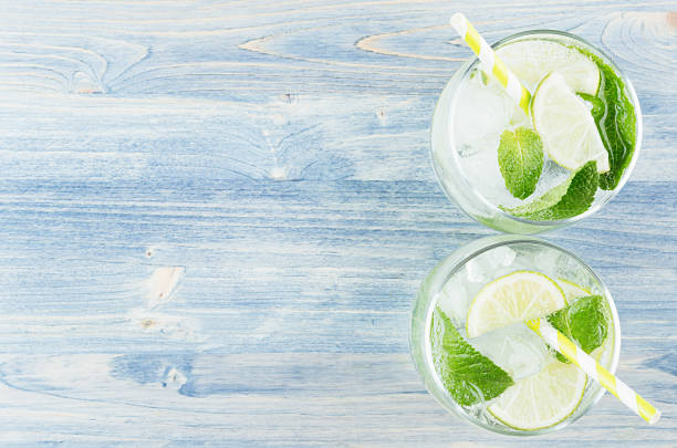 glass of mojito in male hand on laptop background