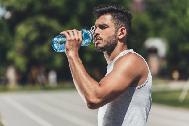 istock sporty young man drinking water after workout 995298868