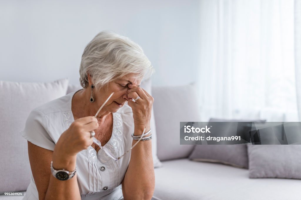 Ältere Frau, die leiden unter Kopfschmerzen zu Hause - Lizenzfrei Alter Erwachsener Stock-Foto