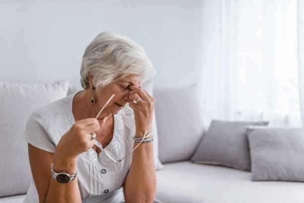 elderly woman suffering from headache at home - old senior adult women tired imagens e fotografias de stock