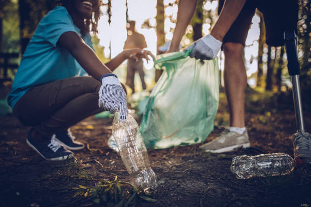 istock Community volunteers cleaning up trash in park 995306056
