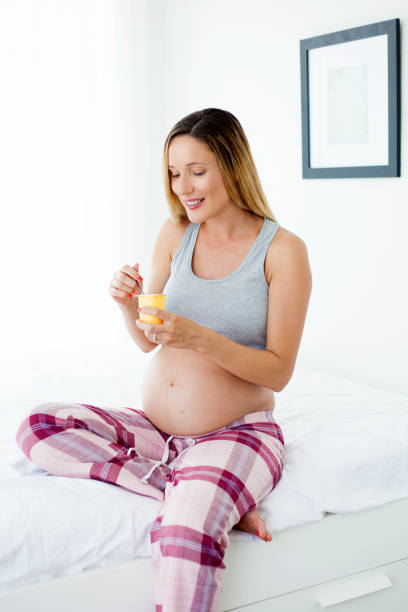 istock Pregnant woman eating yogurt 995306372