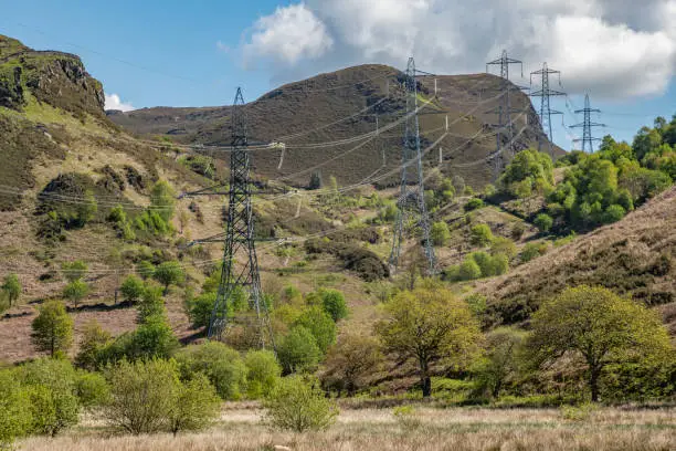 pylons carrying power lines into the distance along a valley