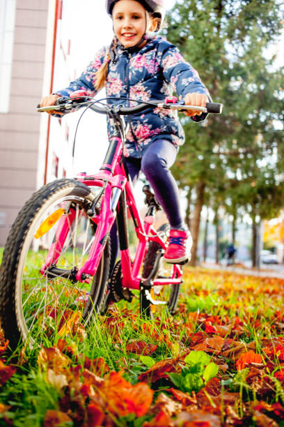 istock Young Girl Enjoying Riding Bicycle in Public Park 995309716