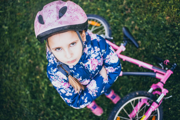 istock Young Grimacing Girl With a Bicycle 995309856