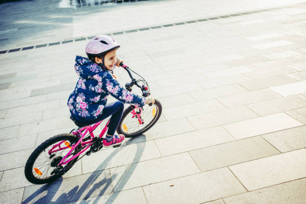 istock Young Girl Enjoying Riding Bicycle on Town Square 995309902