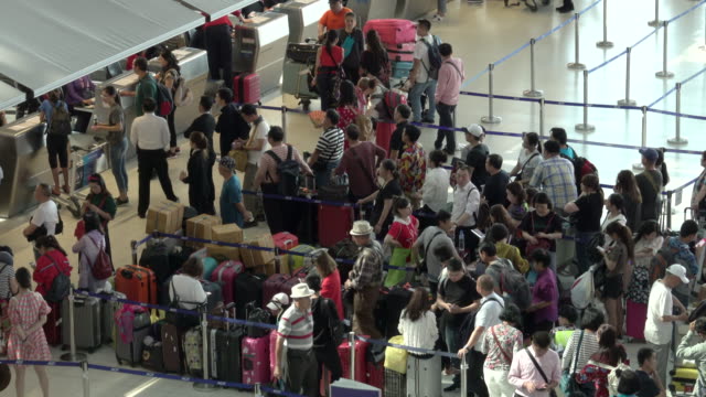 4k: passengers wait at the check in queue in departure terminal of Bangkok Suvarnabhumi Airport