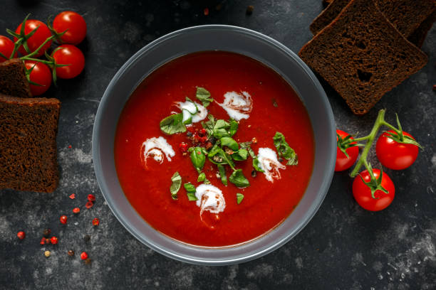 tomaten und frischem basilikum-suppe mit knoblauch, knackte papper hühneraugen, serviert mit sahne und sauerteig brot - mediterranean cuisine mediterranean culture food bread stock-fotos und bilder