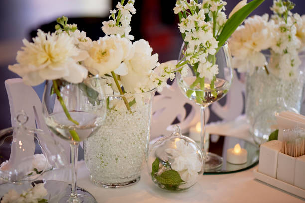 istock Classic table setting. White tablecloth. Vase with hydrogel and white flowers.The table of young. Specific. Flowers in glass 995322974