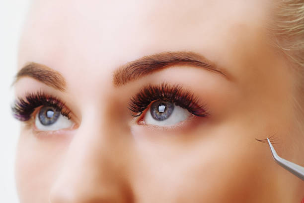 istock Eyelash Extension Procedure. Woman Eye with Long Eyelashes. Close up, selective focus 995323248